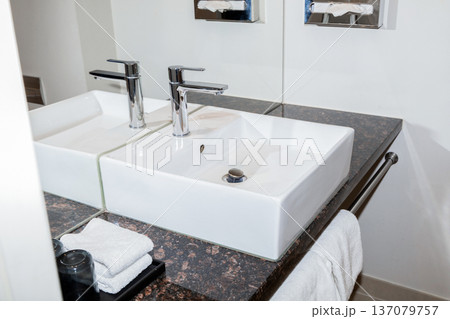 Modern hotel bathroom sink with faucet and towels. 137079757