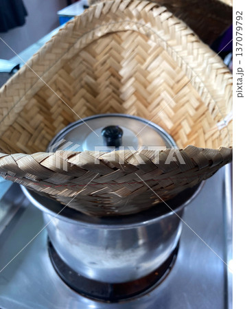 Traditional Thai bamboo steamer placed over a pot, used for cooking sticky rice, showcasing the unique culinary method of preparing Thai desserts 137079792