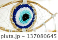 Crochet evil eye amulet integrated into a woven dreamcatcher, representing protection, spirituality, and good luck against negative energy and bad dreams with its intricate blue and white patterns 137080645