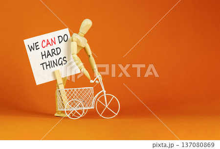 Support, help we can do hard things symbol. Concept words We can do hard things on beautiful white paper. Beautiful orange background. Business we can do hard things concept. Copy space. Support, help we can do hard things symbol. Concept words We can do hard things on beautiful white paper. Beautiful orange background. Business we can do hard things concept. Copy space. 137080869