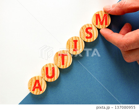Autism medical symbol. Concept word Autism on beautiful wooden circles. Beautiful blue and white background. Doctor's hand. Business autism medical concept. Copy space. 137080955