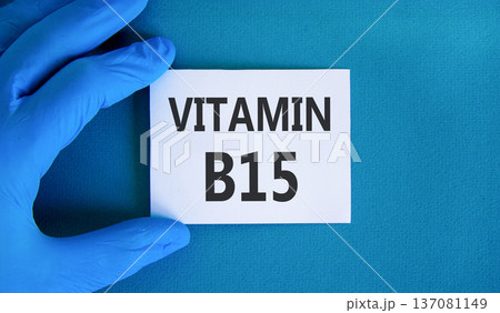 Vitamin B15 pantothenic acid symbol. Concept words Vitamin B15 on beautiful white card. Doctor's hand in blue medical glove. Beautiful blue background. Medical healthy lifestyle Vitamin B15 concept. Vitamin B15 pantothenic acid symbol. Concept words Vitamin B15 on beautiful white card. Doctor's hand in blue medical glove. Beautiful blue background. Medical healthy lifestyle Vitamin B15 concept. 137081149