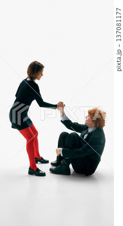 Woman helping seated man stand up holding his hand on white studio background. Woman helping seated man stand up holding his hand on white studio background. 137081177