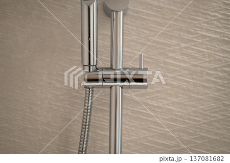 Modern chrome shower head and rail system for a contemporary bathroom, highlighting sleek metallic design and stylish plumbing fixtures Modern chrome shower head and rail system for a contemporary bathroom, highlighting sleek metallic design and stylish plumbing fixtures 137081682