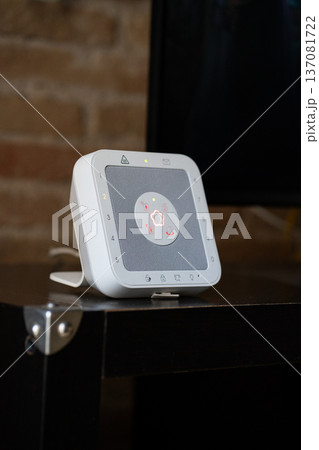 White smart home security hub displaying a central illuminated status light, integrating alarm system functions for modern house protection and automation 137081722