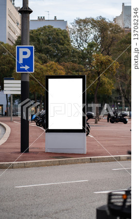 Blank vertical advertising billboard standing on a city street pavement Blank vertical advertising billboard standing on a city street pavement 137082346