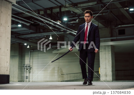 スーツ男性が棒を持つ 137084830