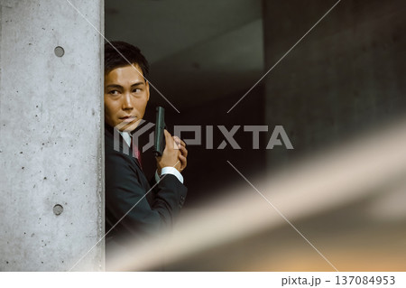 スーツの男が銃構える 137084953