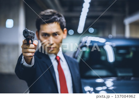 スーツ男性が銃を構える 137084962
