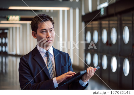 ビジネスマンがタブレット操作 137085142