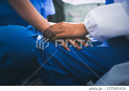Gentle Hand Holding by Healthcare Worker in Teal Scrubs Offering Comfort and Support in Bright Modern Medical Office with Light Gray Background Gentle Hand Holding by Healthcare Worker in Teal Scrubs Offering Comfort and Support in Bright Modern Medical Office with Light Gray Background 137085426