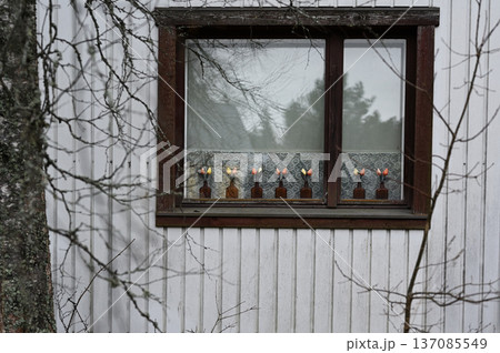 A quiet exterior view of a traditional wooden house window in a rural Nordic setting A quiet exterior view of a traditional wooden house window in a rural Nordic setting 137085549