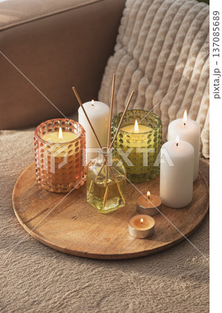 Candles and Reed Diffuser on Wooden Tray. Cozy Home Decor lifestyle with Cushions 137085689