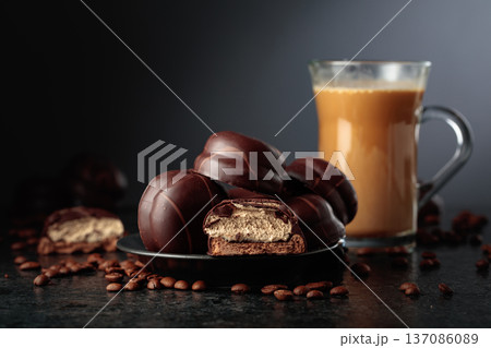 Chocolate dessert and cup of coffee with cream on a black table. Chocolate dessert and cup of coffee with cream on a black table. 137086089