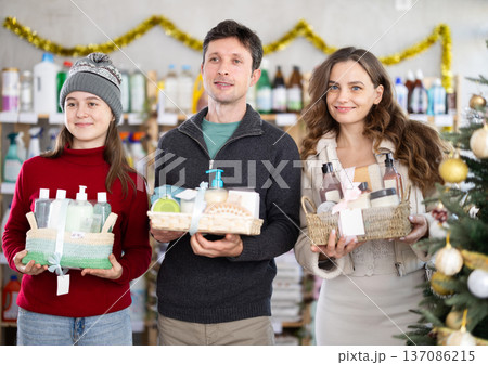 Couple man and woman with daughter chooses cosmetics gift set 137086215