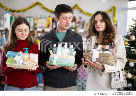 Couple man and woman with daughter chooses cosmetics gift set Couple man and woman with daughter chooses cosmetics gift set 137086220