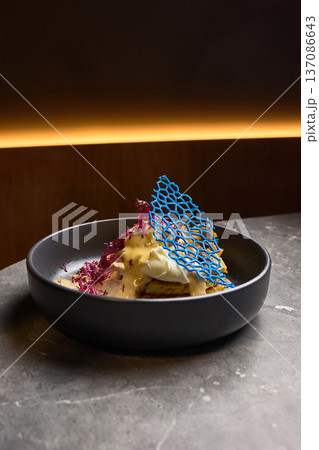 Exquisite plated dessert with unique blue decoration and delicate cream presentation, gourmet dining concept 137086643