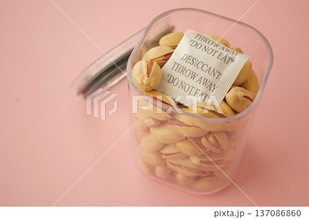 Container holding pistachios with desiccant warning label 137086860