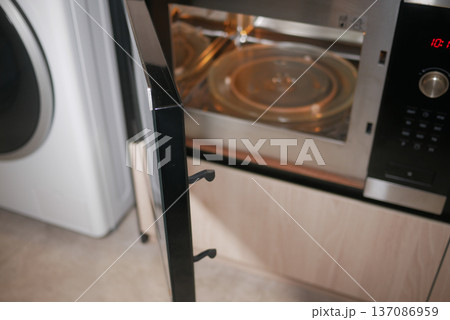Microwave door is open in a kitchen setting 137086959