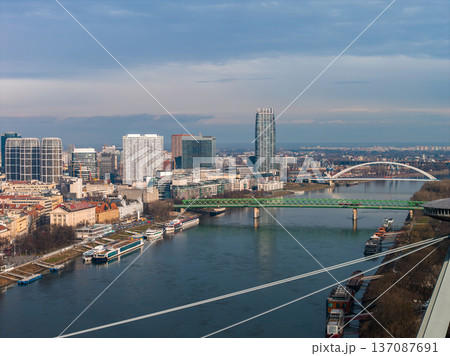 Aerial view of Bratislava, Slovakia, shows the Danube, green Stary most, white Apollo Bridge, Panorama City tower, River Park, Eurovea, and river boats in soft winter light. Aerial view of Bratislava, Slovakia, shows the Danube, green Stary most, white Apollo Bridge, Panorama City tower, River Park, Eurovea, and river boats in soft winter light. 137087691