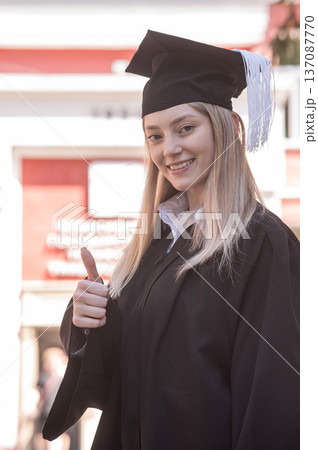 Portrait of a young Caucasian woman in a graduation gown. Portrait of a young Caucasian woman in a graduation gown. 137087770