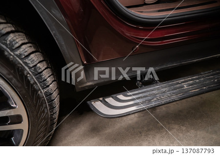 Folding step of a red modern car.  137087793