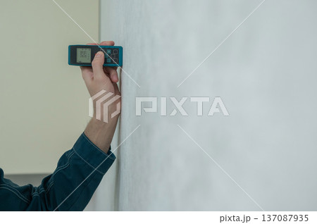 The master uses a laser tape measure. The master uses a laser tape measure. 137087935