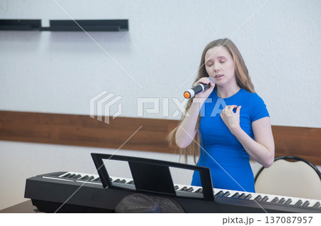 Caucasian woman singing into microphone. Caucasian woman singing into microphone. 137087957