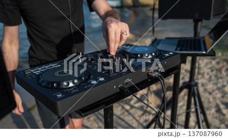 Close up of DJ's hands while working outdoors. Close up of DJ's hands while working outdoors. 137087960