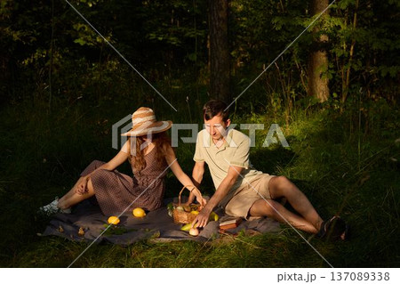 Sunset light bathes couple sharing casual outdoor meal happily 137089338