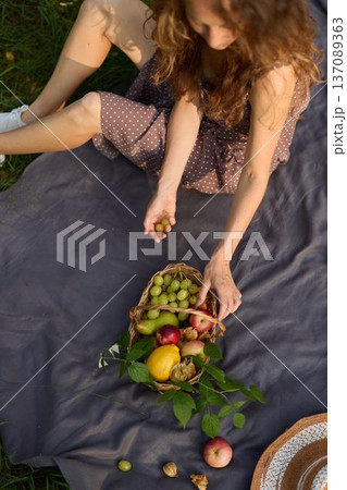 An intimate setting with woman organizing fruits on blanket 137089363