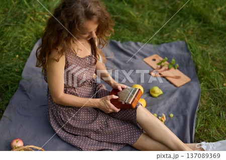 Woman engages with book amidst bright grass field Woman engages with book amidst bright grass field 137089369