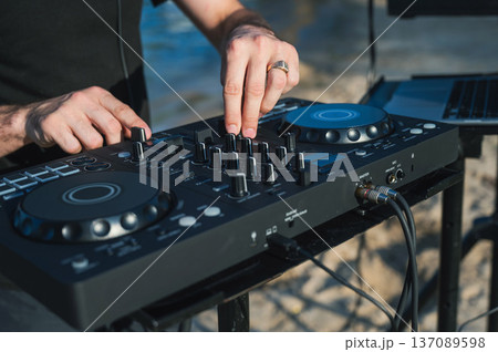Close up of DJ's hands while working outdoors. Close up of DJ's hands while working outdoors. 137089598