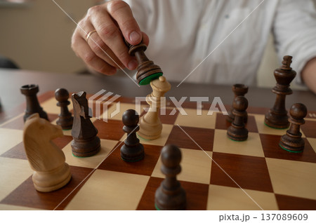 Close up of hands of middle aged caucasian man playing chess.  137089609