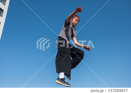 A girl jumps on an outdoor trampoline. A girl jumps on an outdoor trampoline. 137089657