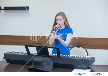 Caucasian woman singing into microphone. Caucasian woman singing into microphone. 137089699