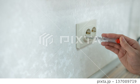 The technician determines the voltage in the socket. The technician determines the voltage in the socket. 137089719