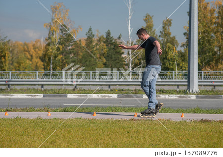 A Caucasian man rollerblades around the slalom course. 137089776