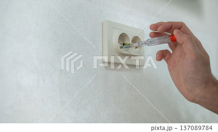 The technician determines the voltage in the socket. The technician determines the voltage in the socket. 137089784