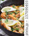Haddock fish piccata with lemon and capers in cast iron pan, vertical closeup 137090403