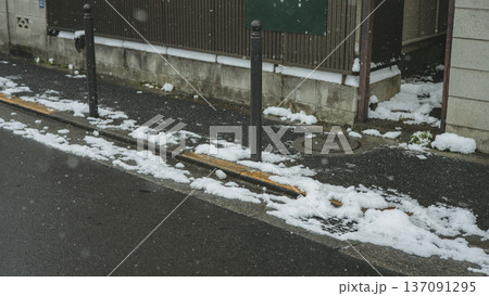 東京の住宅街　雪が残る側溝と冬の道路風景 137091295