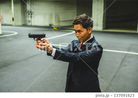 スーツ男性が銃を構える 137091623