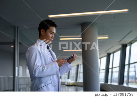白衣の男性がタブレット操作 白衣の男性がタブレット操作 137091759
