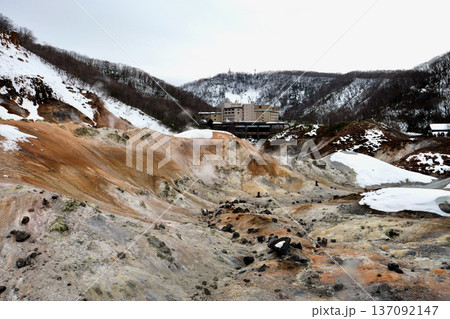 冬の「登別地獄谷」白い雪と茶色い山肌　奥に温泉街 137092147