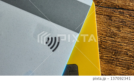 Close-up of credit cards showing the contactless payment symbol on a wooden background 137092341