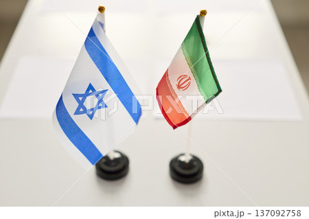 Israel and Iran flags on negotiation table, symbol of meeting diplomacy today Israel and Iran flags on negotiation table, symbol of meeting diplomacy today 137092758