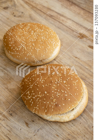 empty sesame burger buns arranged on a wooden table ready for cooking 137093280
