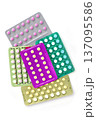 Collection of hormonal birth control pills in different colors and packaging. 137095586