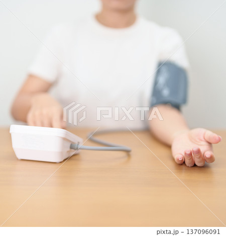woman checking Blood pressure by Blood pressure monitor with Cuff. Systolic, SYS, Diastolic, DIA, Pulse, Hypertension, Hypotension, Heart rate, Cardiovascular Disease and May World hypertension day 137096091