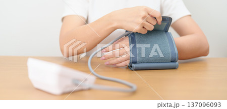 woman checking Blood pressure by Blood pressure monitor with Cuff. Systolic, SYS, Diastolic, DIA, Pulse, Hypertension, Hypotension, Heart rate, Cardiovascular Disease and May World hypertension day woman checking Blood pressure by Blood pressure monitor with Cuff. Systolic, SYS, Diastolic, DIA, Pulse, Hypertension, Hypotension, Heart rate, Cardiovascular Disease and May World hypertension day 137096093